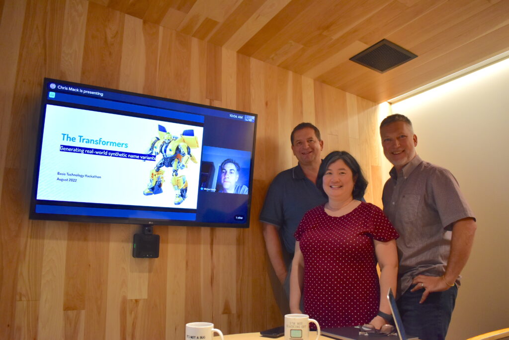 Photograph of Team 5 member Peter De Bie, Karin Lin, and Chris Mack, joined by Mike Harris on-screen via video chat.